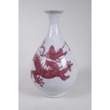 A Chinese red and white porcelain pear shaped vase decorated with a dragon chasing the flaming
