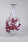 A Chinese red and white porcelain pear shaped vase decorated with a dragon chasing the flaming