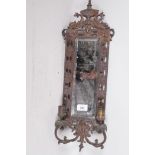 A bronzed metal two branch wall sconce, with inset bevelled glass mirror and dolphin crest, 23" x 7"