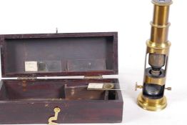 A small brass field microscope with slides, in a wooden box, 6¼" long