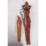 A carved hardwood nutcracker in the form of a female nude 13" long, together with another carved