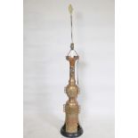 A painted brass floor lamp with pierced body and Oriental style raised decoration, on a wood base,