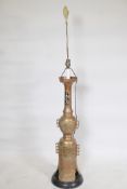 A painted brass floor lamp with pierced body and Oriental style raised decoration, on a wood base,