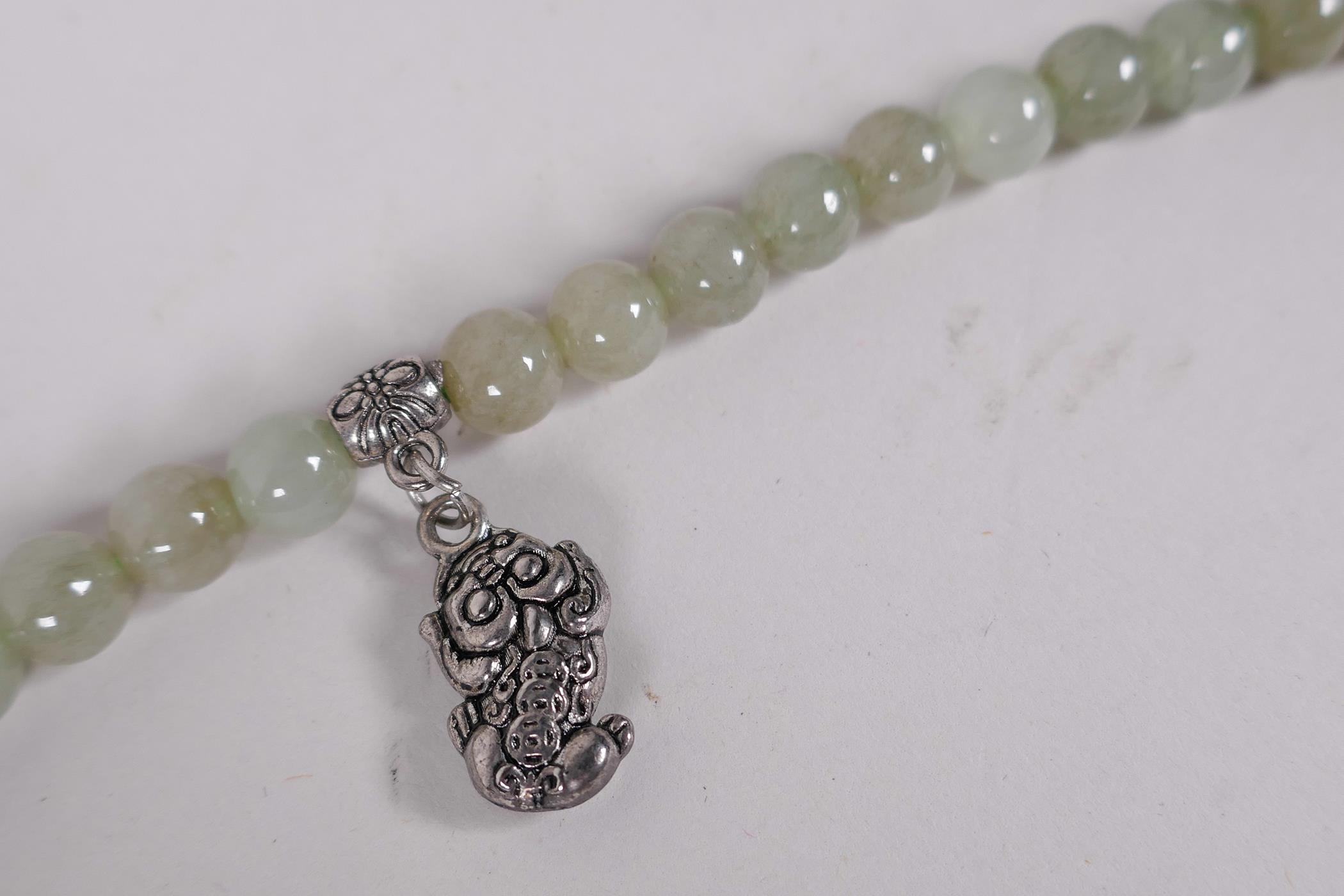 A Chinese celadon jade necklace, 27" long - Image 2 of 4