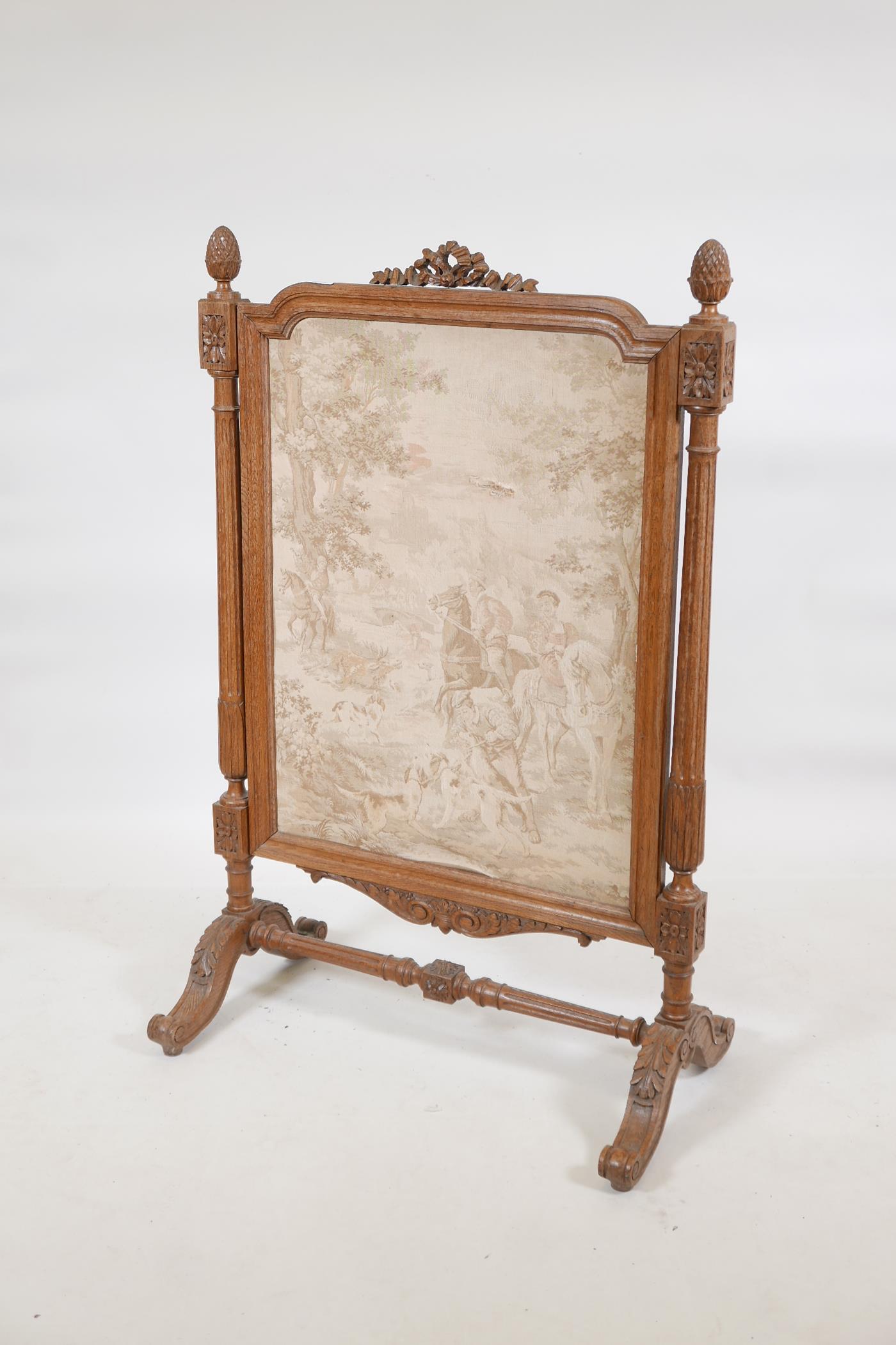 A C19th French carved oak fire screen, with pineapple and patarae decoration and fluted columns