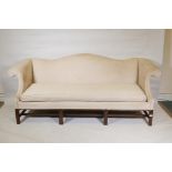 A Chippendale style camel back settee with scroll arms, raised on moulded chamfered supports