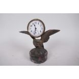 A small bronze figure of an eagle with a clock on its back mounted on a marble plinth, 5" high