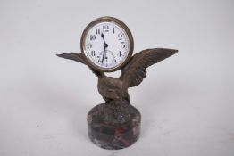 A small bronze figure of an eagle with a clock on its back mounted on a marble plinth, 5" high