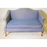 A Chippendale style two seater hump back settee with scroll arms, raised on cabriole supports with