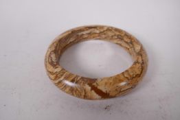 An Oriental calcified wood bangle, 2½" diameter