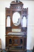 A Victorian walnut hall stand, with broken pediment top over an oval mirror with all over carved