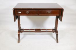 A mahogany two drawer sofa table, raised on triple end columns and cabriole supports, with brass