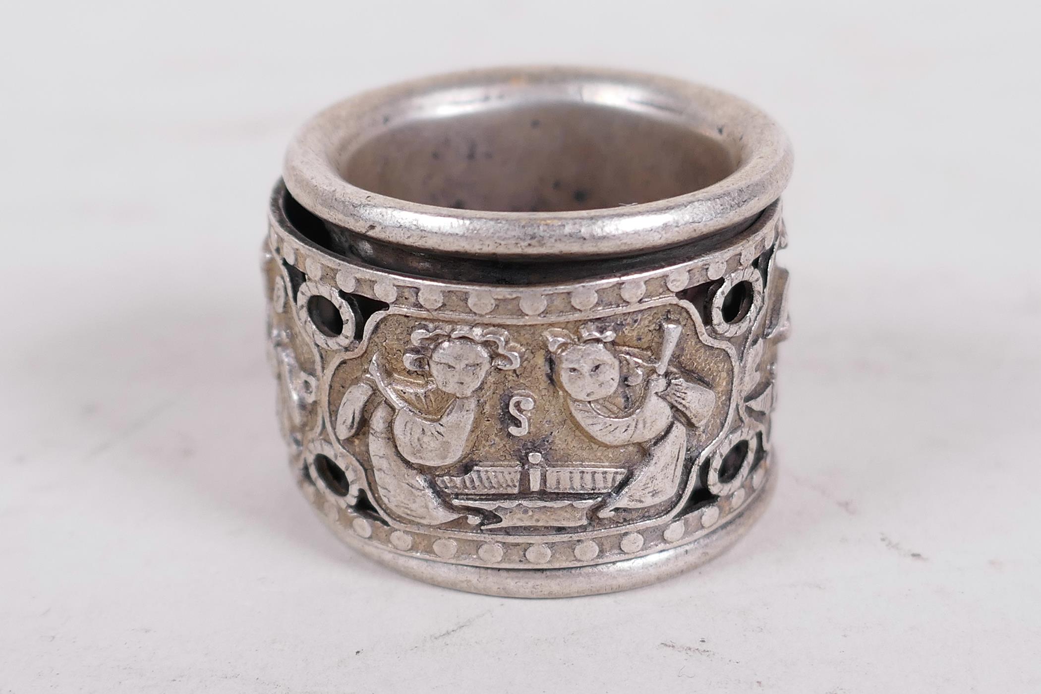 A Chinese white metal archer's ring with revolving centre section decorated with figures