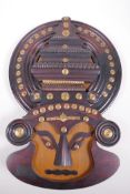 An Indian Kathakali wooden wall mask decorated with brass studding, 17" x 12"