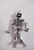 An articulated silver skeleton pendant, 2" long