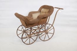 A vintage cane and wood frame child's pram, with steel rimmed wheels, 41" x 19" x 29"