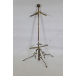 An early C20th brass valet stand raised on tripod supports, 56" high
