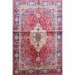 A red ground full pile Kashmir rug with a floral medallion design, 46" x 68"