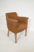 A 1930s tub shaped chair, raised on tapering supports, and a 1920s high back armchair, raised on