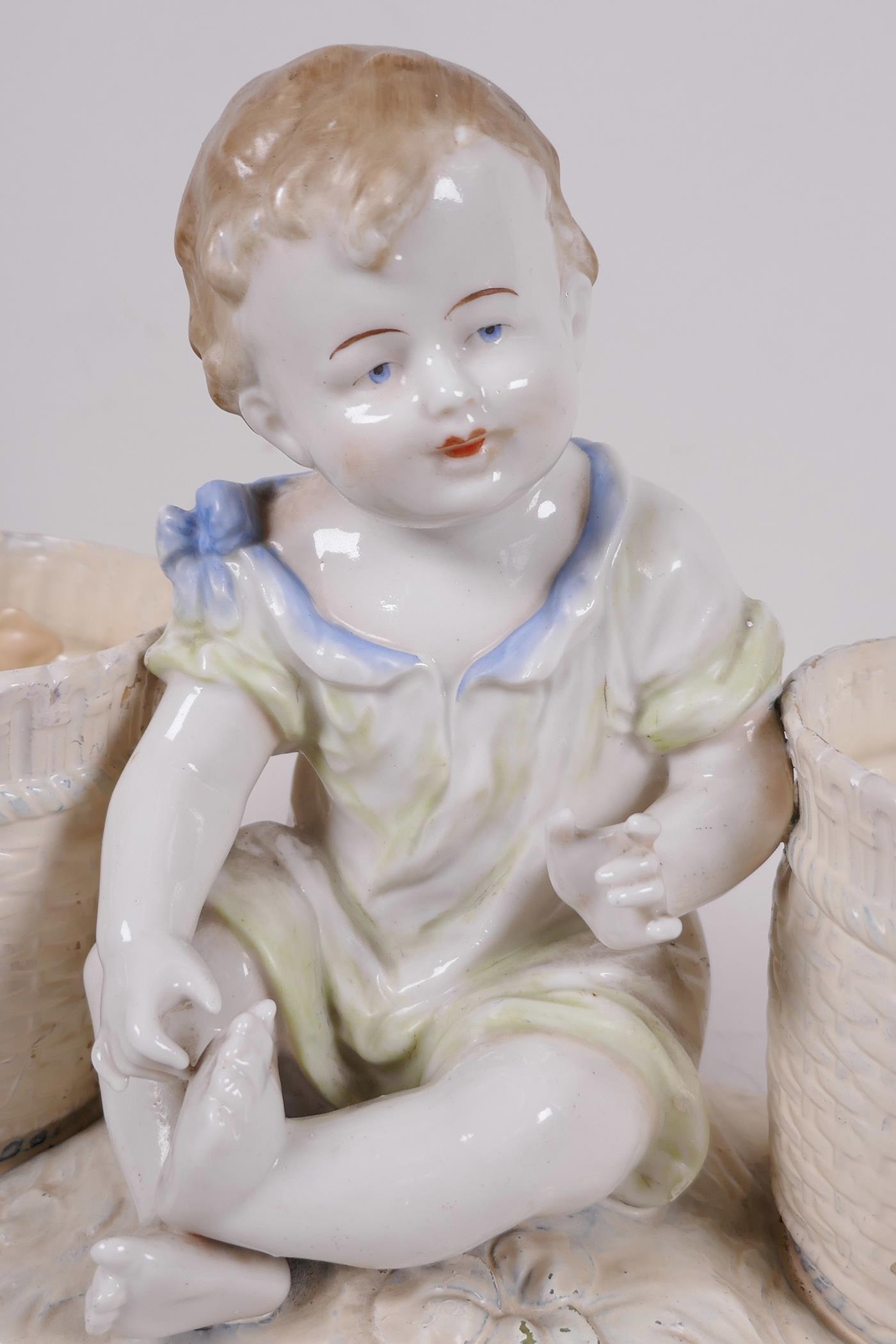 A decorative porcelain planter in the form of a young girl seated between two large baskets, 11½" - Image 2 of 3