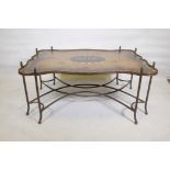 A painted metal framed low table, with hand painted shaped top, raised on sabre supports with