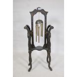 An ebonised stand, with polychrome painted chinoiserie decoration, incorporating a hanging bell/gong