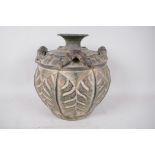 An Oriental pottery vase with four handles modelled as bamboo, the body carved with monstera leaves,