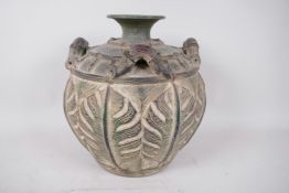 An Oriental pottery vase with four handles modelled as bamboo, the body carved with monstera leaves,