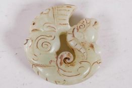 A pale green hardstone roudel carved as a mythical beast, 2" diameter