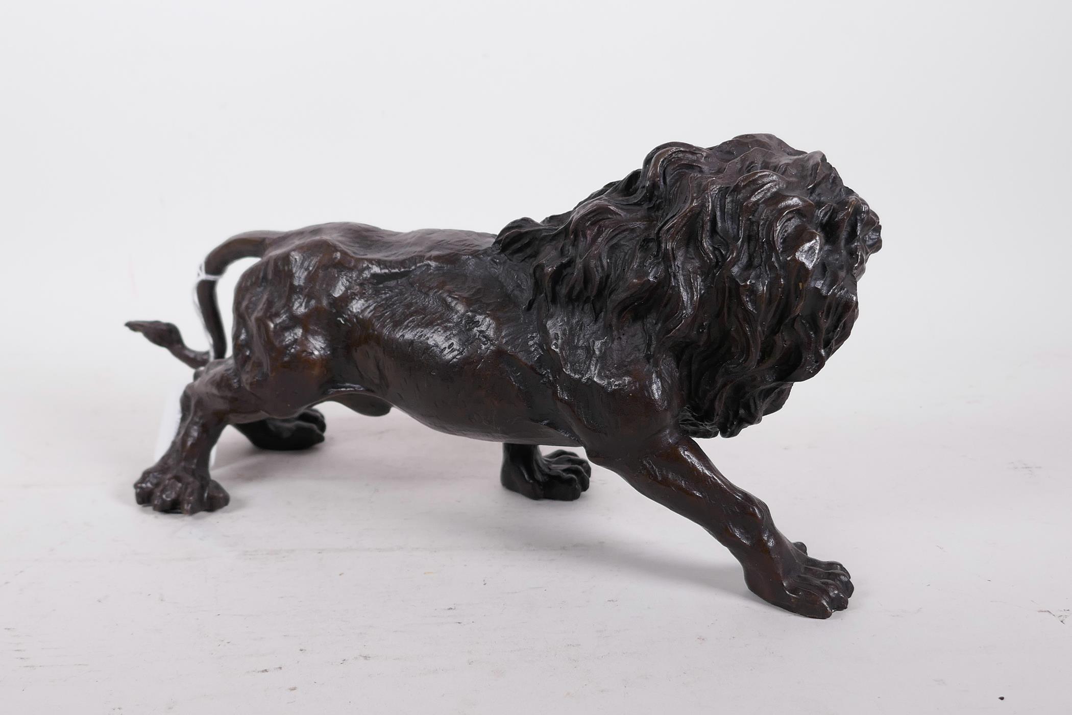 A hollow cast patinated brass figure of a lion, 12" long - Image 4 of 6