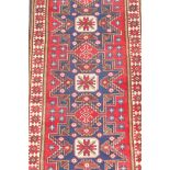 A vintage fine woven red ground Turkish rug with a blue starburst design, woven on wool, 42" x 76"