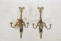 A pair of brass three branch wall sconces, with floral and scroll decoration, 27" high