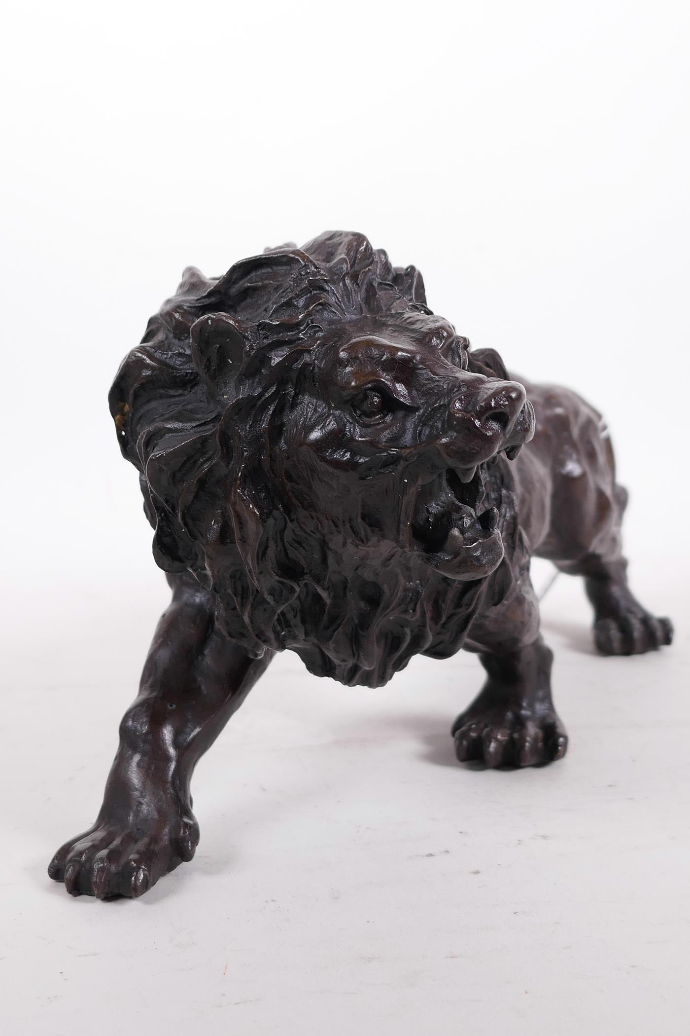 A hollow cast patinated brass figure of a lion, 12" long - Image 3 of 6