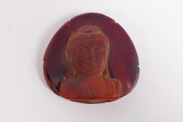 A Chinese horn and hoof pendant with raised Buddha decoration, 2½" x 2½"