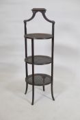 A three tier cake stand with inset cane panels, raised on reeded sabre supports, early C20th, 33"