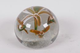 A heavy glass paperweight decorated with lilies, 3½" diameter