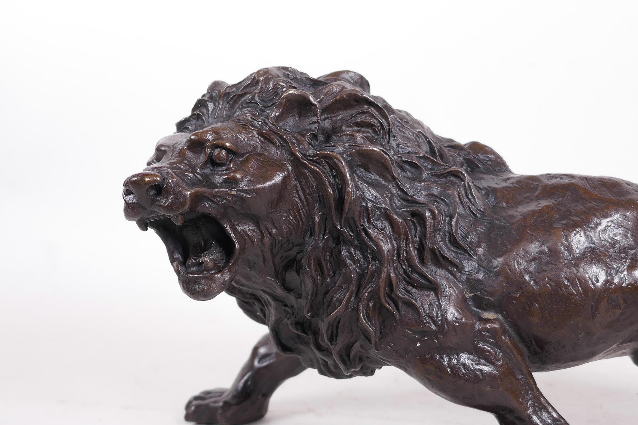A hollow cast patinated brass figure of a lion, 12" long - Image 2 of 6