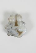 A Chinese grey hardstone pendant with erotic carving, 2" diameter