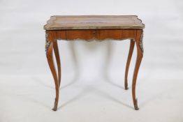 A C19th French rosewood writing table, with brass mounts, the shaped top inset with blind tooled