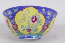 A Chinese porcelain bowl with blue ground and yellow panels painted with flowers, red seal mark to
