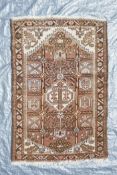 A Persian brown and cream ground wool prayer rug, with a geometric medallion design, 50" x 34"