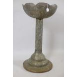 An Indo-Persian pierced brass pedestal with basket top decorated with script and flowers, 39" high