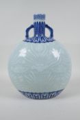 A Chinese blue and white porcelain two handled moon flask, with raised decoration of carp in a lotus