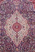 A rich blue ground full pile Kashan rug with a traditional floral medallion pattern, 94" x 63"
