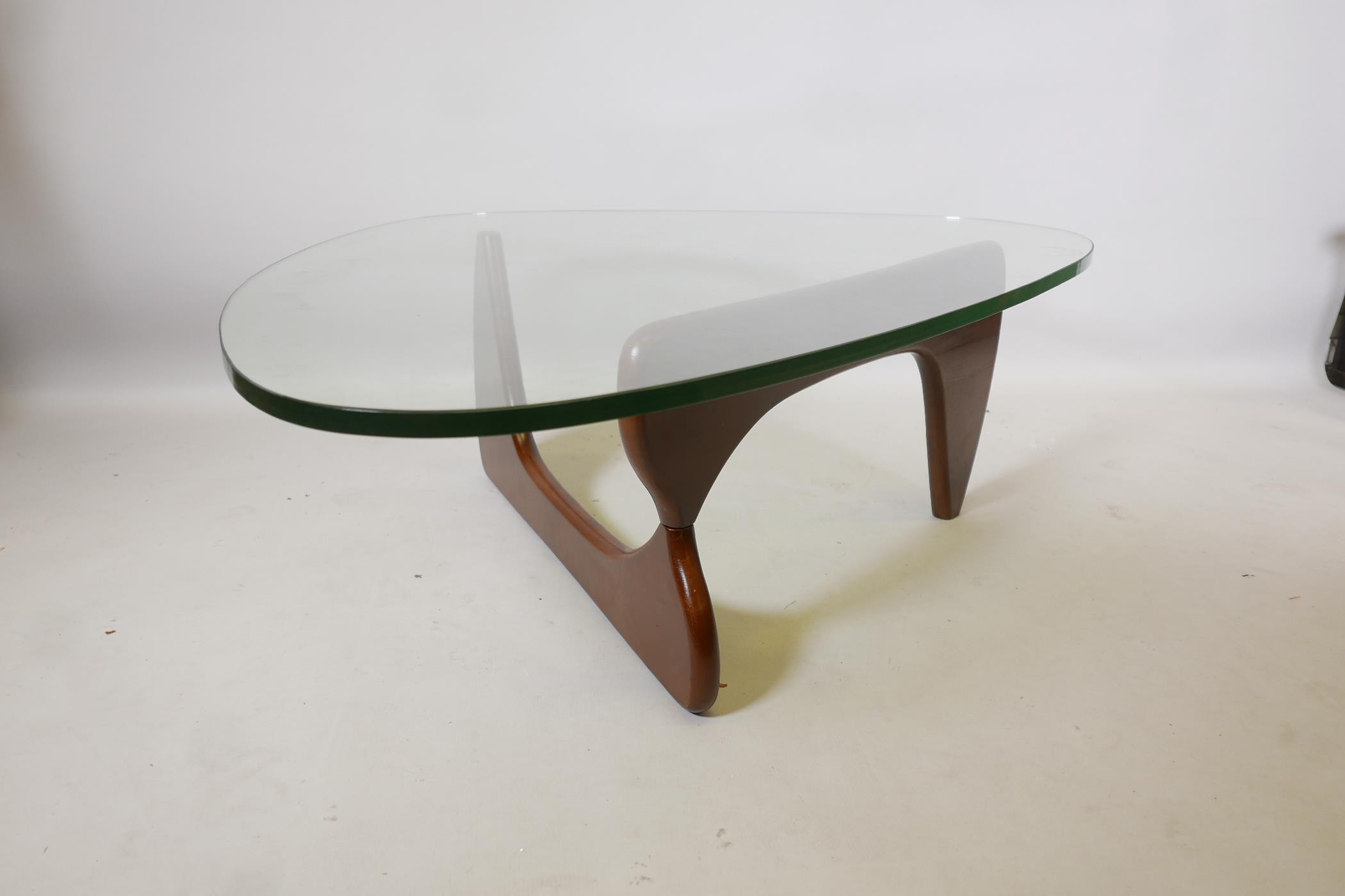 An Isamu Noguchi style pebble shaped coffee table with glass top, 50" x 37½", 16" high