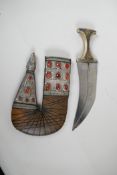 An Eastern jambiya, the bone handle set with plaques depicting St George and the Dragon, the leather