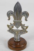 A chrome plated 'Boy Scout' staff head mounted on a turned wooden stand, 8" high