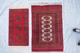 A red ground Turkmen wool rug with a Bokhara design on a cream field, 32" x 48", and another
