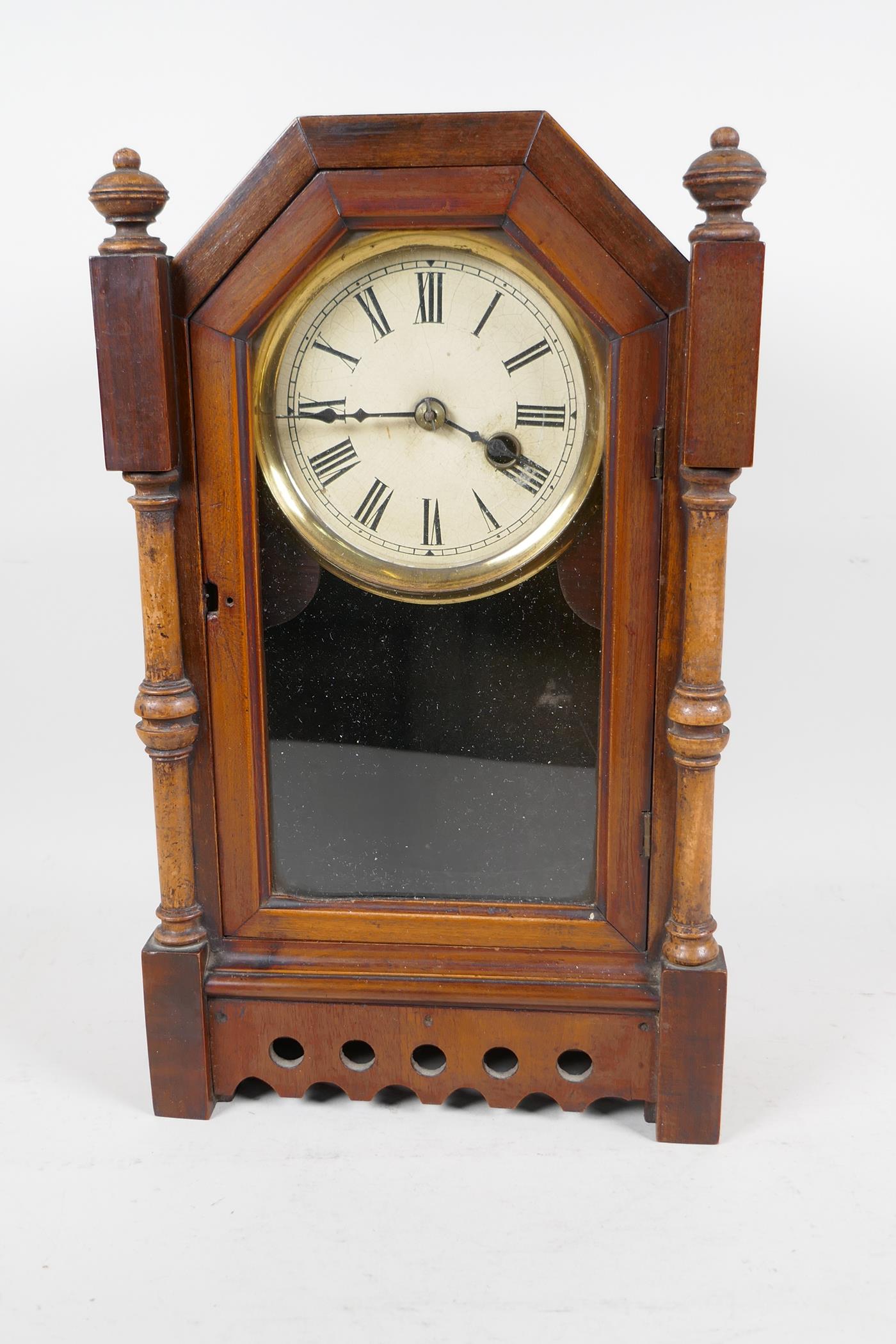 A walnut cased timepiece mantel clock, the case with turned column sides and pierced decoration,