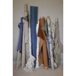 Ten bolts of assorted fabric, in varying lengths and sizes